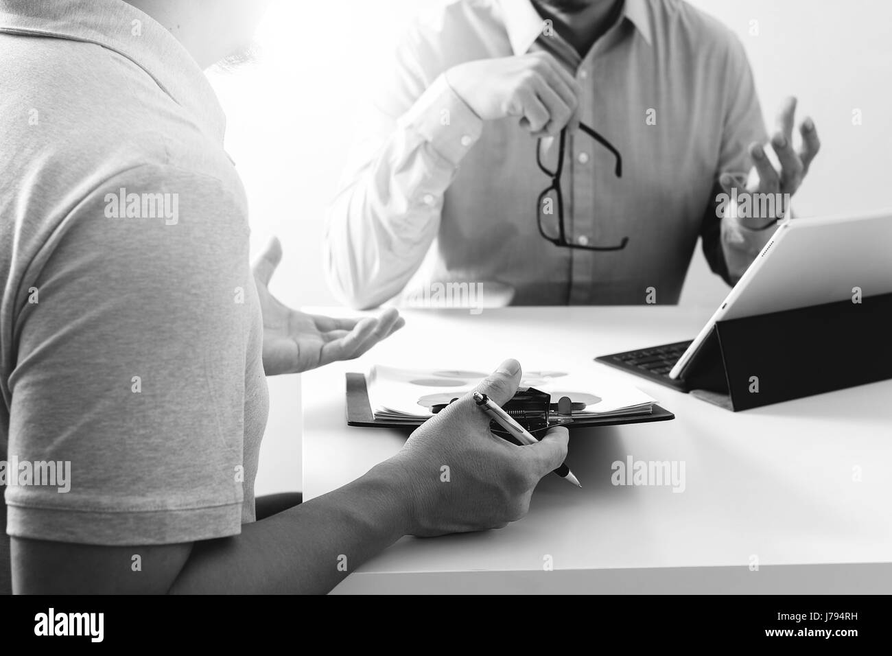 Les hommes d'affaires de travailler ensemble sur un document et à l'aide de smart phone et tablette numérique et un ordinateur portable dans un bureau moderne avec icône VR,schéma noir un Banque D'Images
