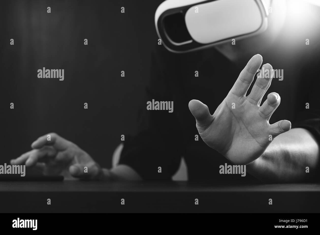 Businessman wearing lunettes de réalité virtuelle dans un bureau moderne avec téléphone portable à l'aide de casque VR avec noir et blanc, Banque D'Images