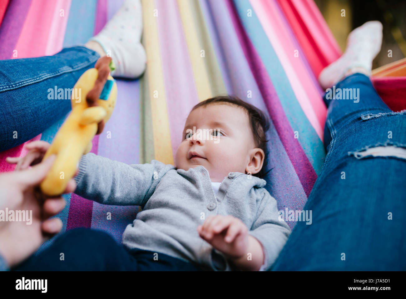 Mère et fille bébé allongé sur un hamac à jouer ensemble Banque D'Images