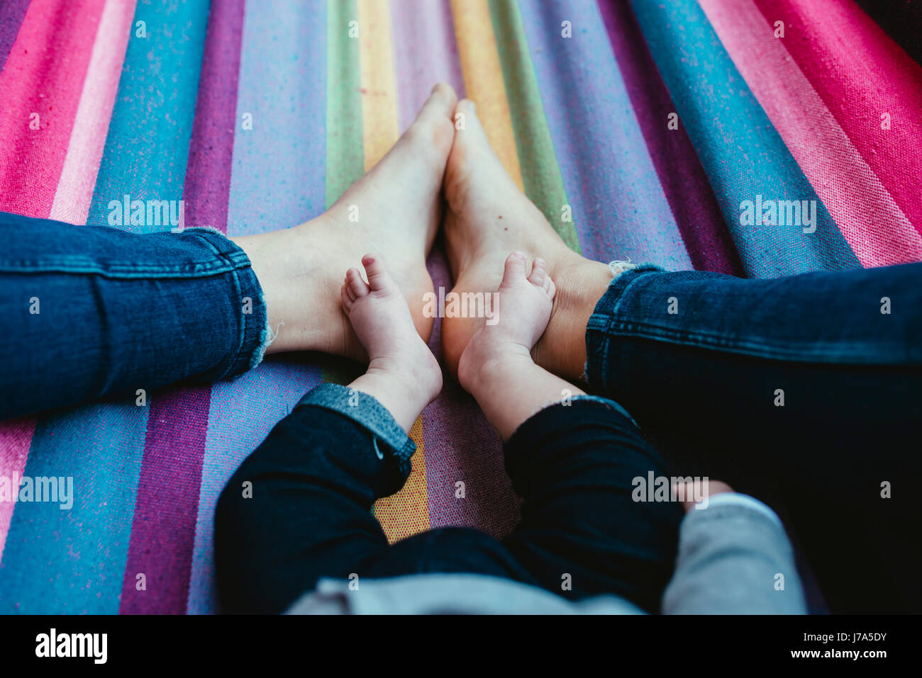 Mère et bébé girl lying pieds nus sur un hamac, vue partielle Banque D'Images