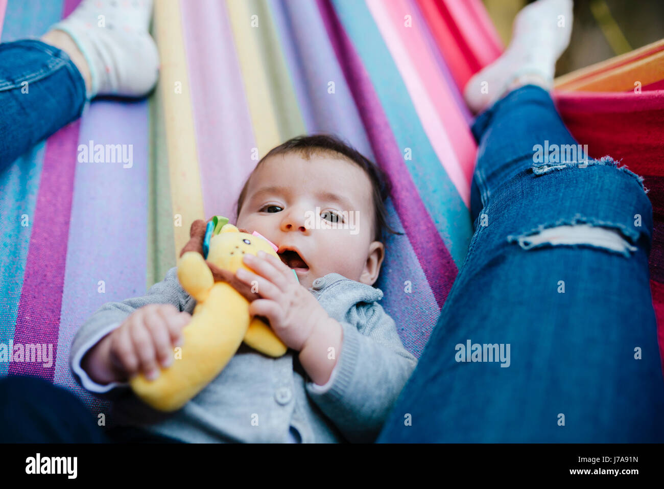 Portrait of baby girl allongé sur un hamac avec sa mère Banque D'Images