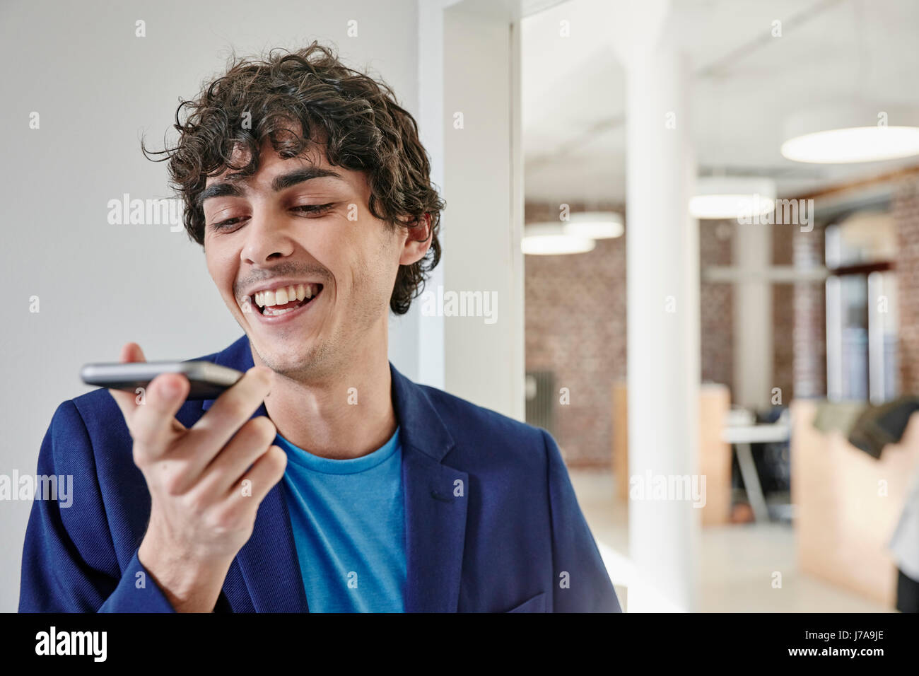 Young man working in office, en laissant un message vocal Banque D'Images