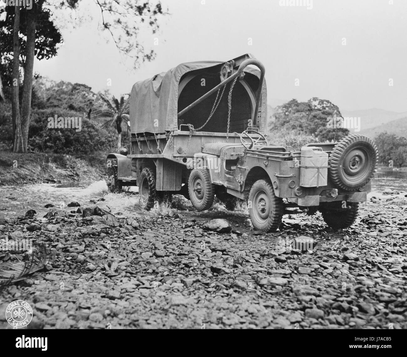 Un camion militaire américaine avec wrecker mont de remorquage d'une jeep, 1942. Banque D'Images