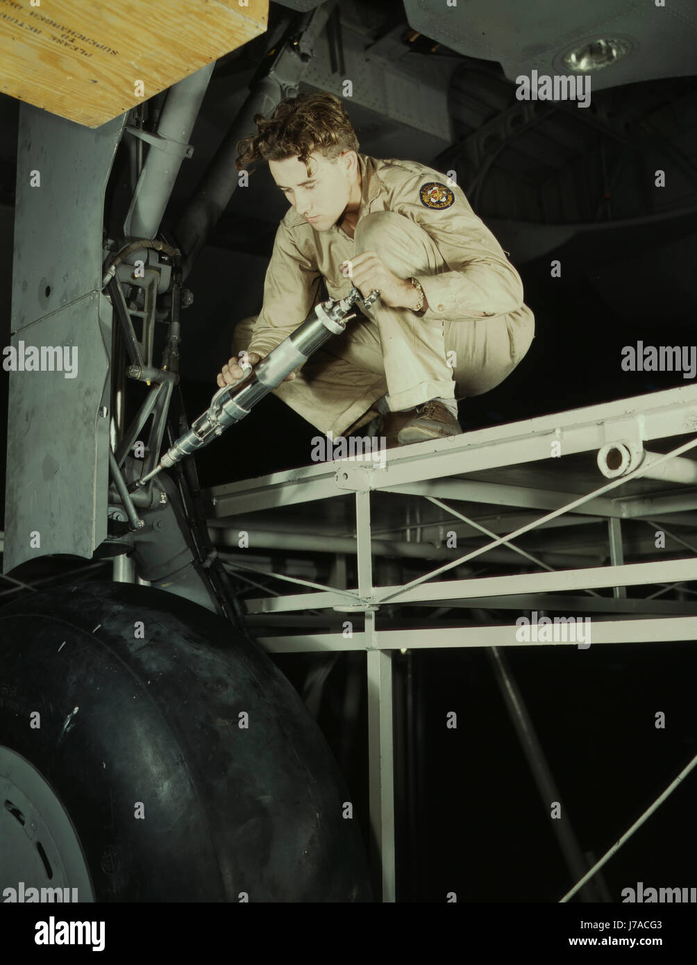 Un mécanicien graissage du train d'atterrissage d'un avion de transport, 1942. Banque D'Images