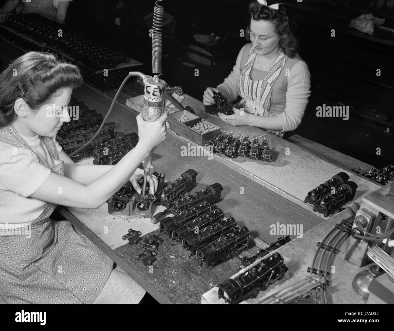 Les femmes qui travaillent à l'aide d'un tournevis électrique pour assembler les trains jouets, 1942. Banque D'Images