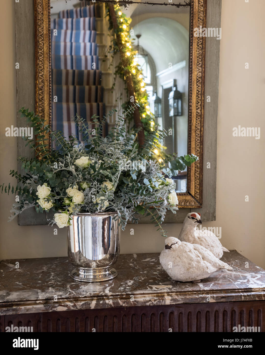 Couple d'oiseaux en haut d'un torse recouvert de marbre avec posy d'argent et de fleurs blanches Banque D'Images