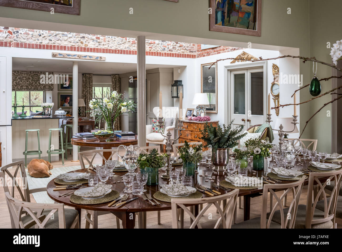 Cuisine spacieuse et salle à manger. La dix-huitième-siècle acajou table est dressée avec des cristaux et des blocs, des serviettes en lin imprimé. Les chaises sont Banque D'Images