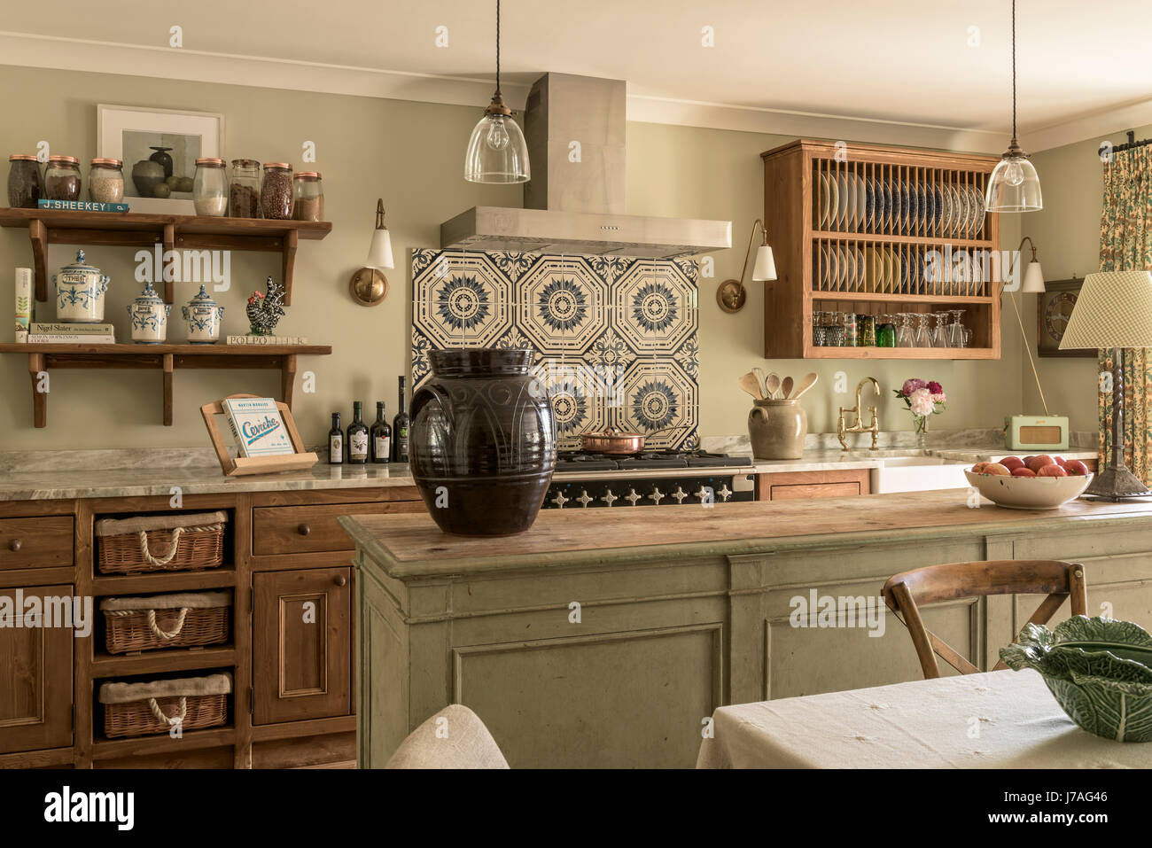 Vieux carreaux Minton au-dessus de la plage de cuisine dans un cadre élégant et agréable cuisine équipée avec pin ciré et unités de l'île de bouchers. La poignée de lumières sont de Hector Finch Banque D'Images