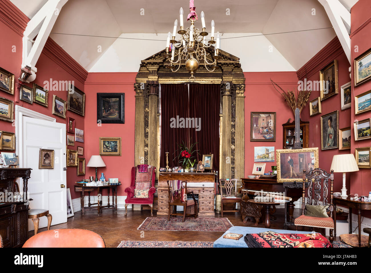 Une grande récupération de 15ème siècle en bois doré et velours by lippi filippino fronton autour de rideau fenêtre dans salle de dessin peint dans le livre de Farrow & Ball Salle Rouge Banque D'Images