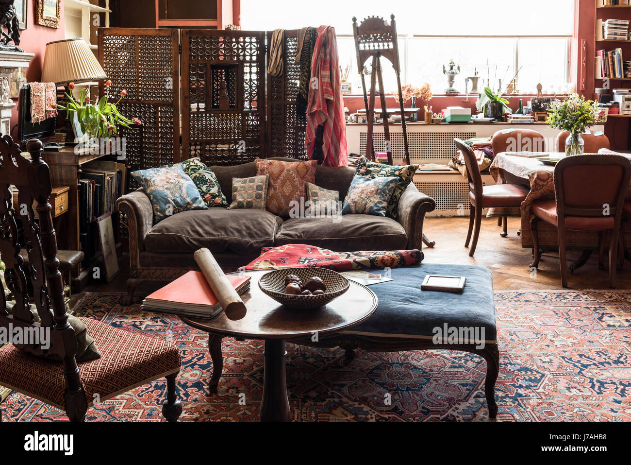 Salon avec un canapé et d'une bergère de style Victorien Charles II fauteuil de style. Au-delà de l'écran sont les peintures et un vieux chevalet. Les murs sont Banque D'Images