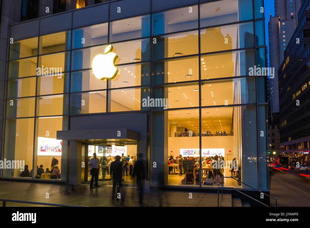 Apple Store Cinquième Avenue extérieur avec l'intérieur les acheteurs au crépuscule, Manhattan, New York, USA Banque D'Images