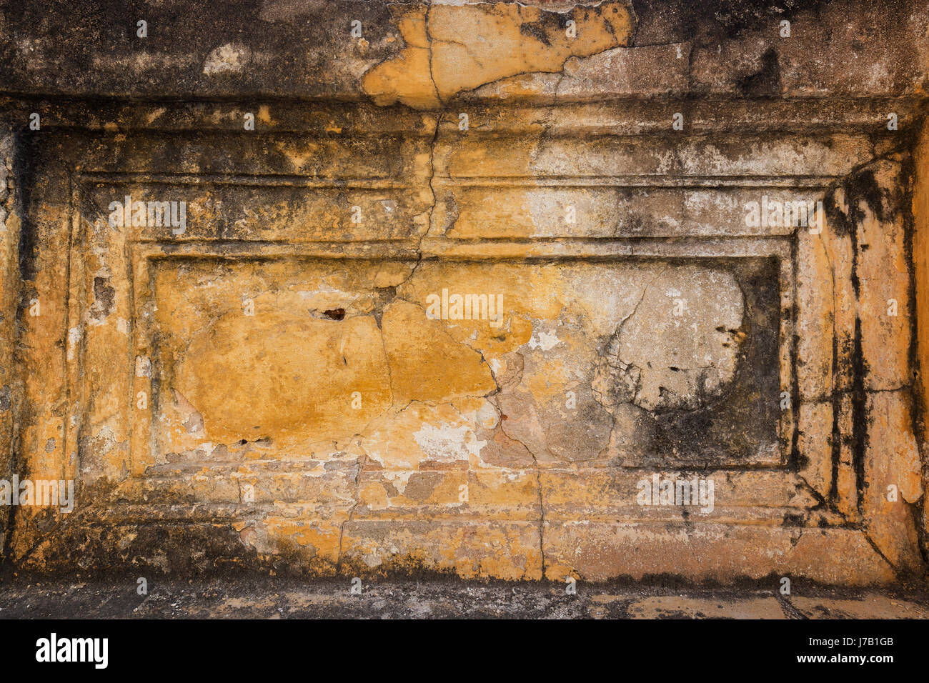 Endommagé, vieux et le plâtre écaillé d'un mur d'orange avec le vignetage. Banque D'Images Endommagé, vieux et le plâtre écaillé d'un mur d'orange avec le vignetage. Banque D'Images