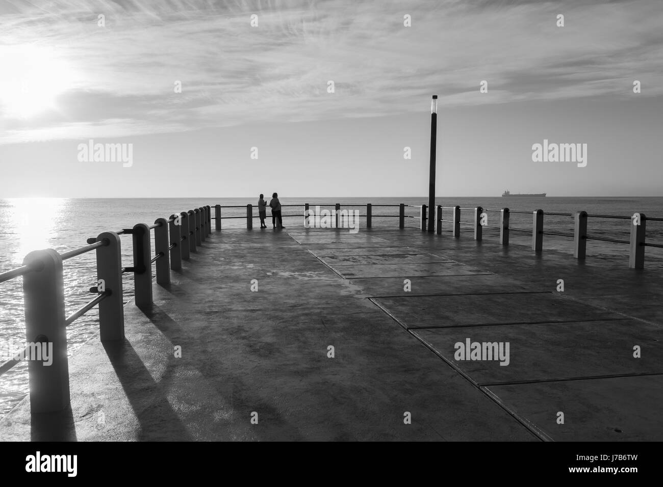 Les gens qui se profile fin de l'article beach ocean pier jetée. Banque D'Images