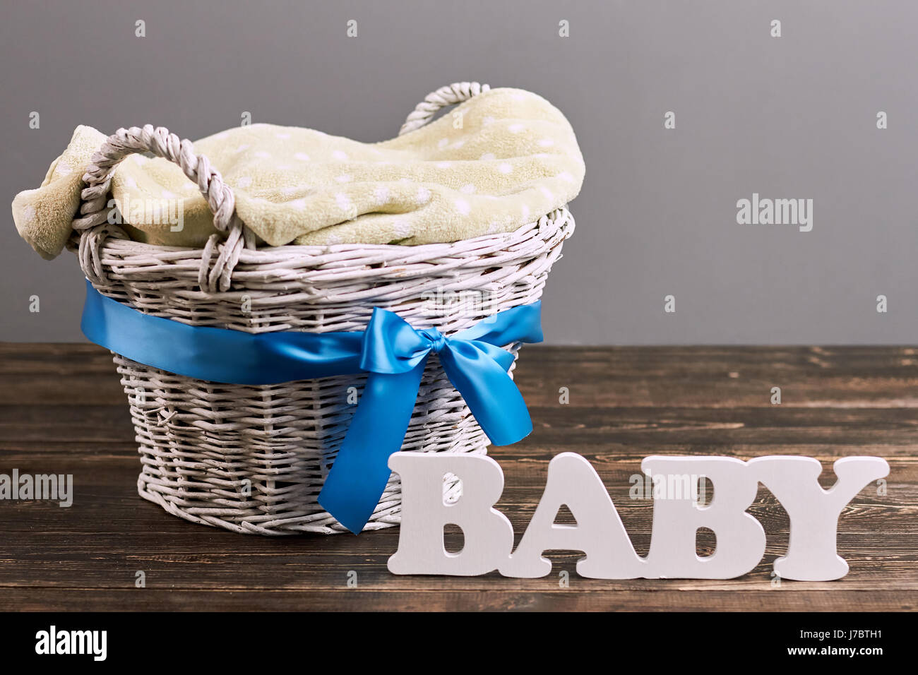 Panier avec bow, lettrage de bébé. Panier en osier et une serviette. Guide pour les parents de première fois. Banque D'Images