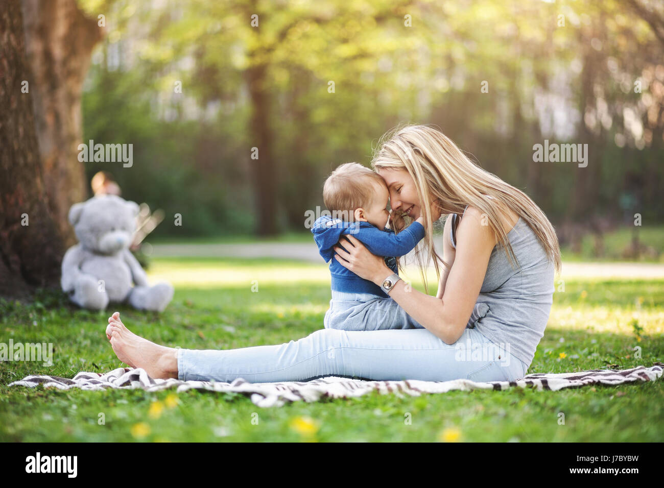 Heureuse mère avec son fils âgé d'un an à l'extérieur dans un parc Banque D'Images