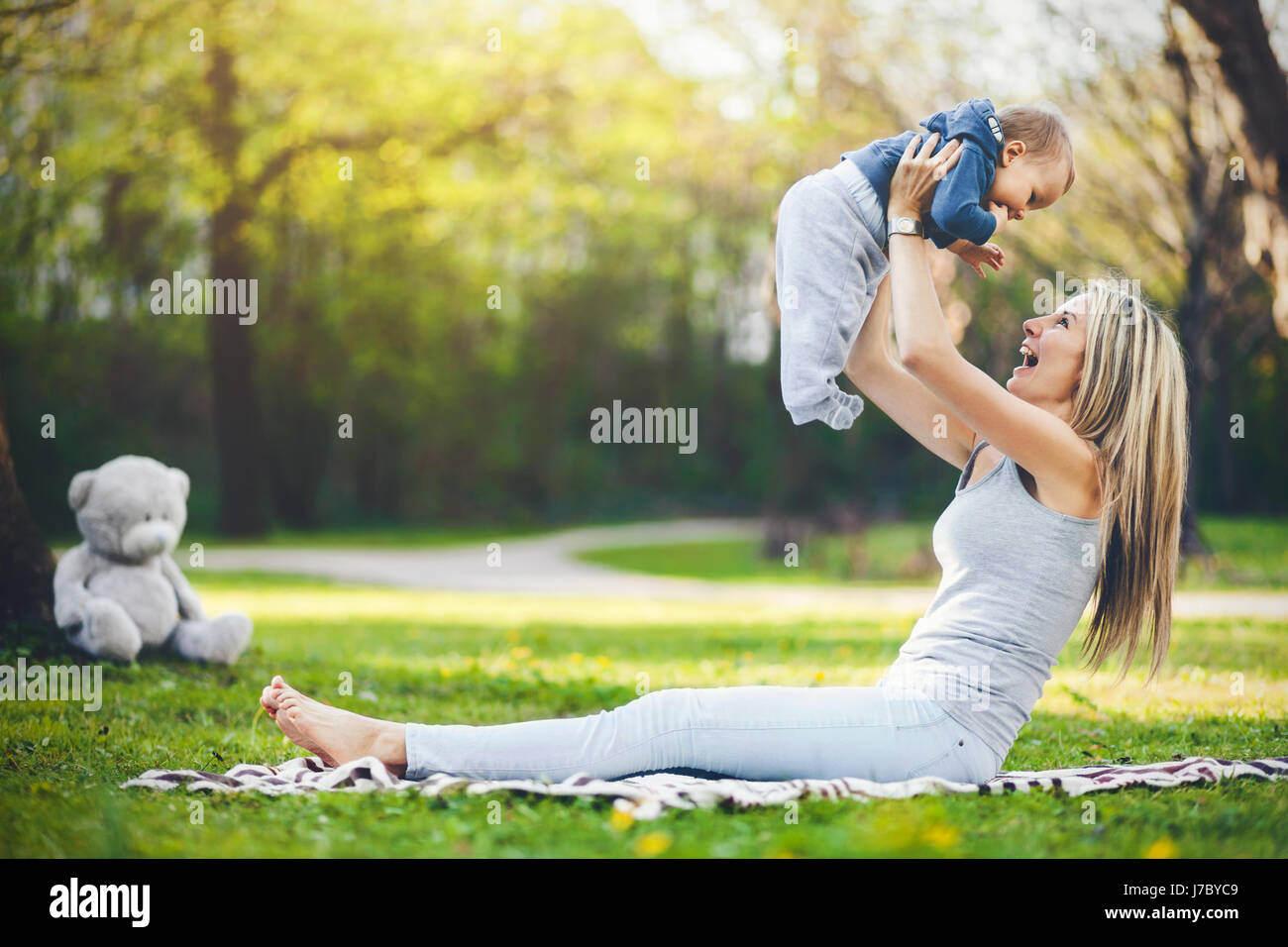 Heureuse mère avec son fils âgé d'un an à l'extérieur dans un parc Banque D'Images