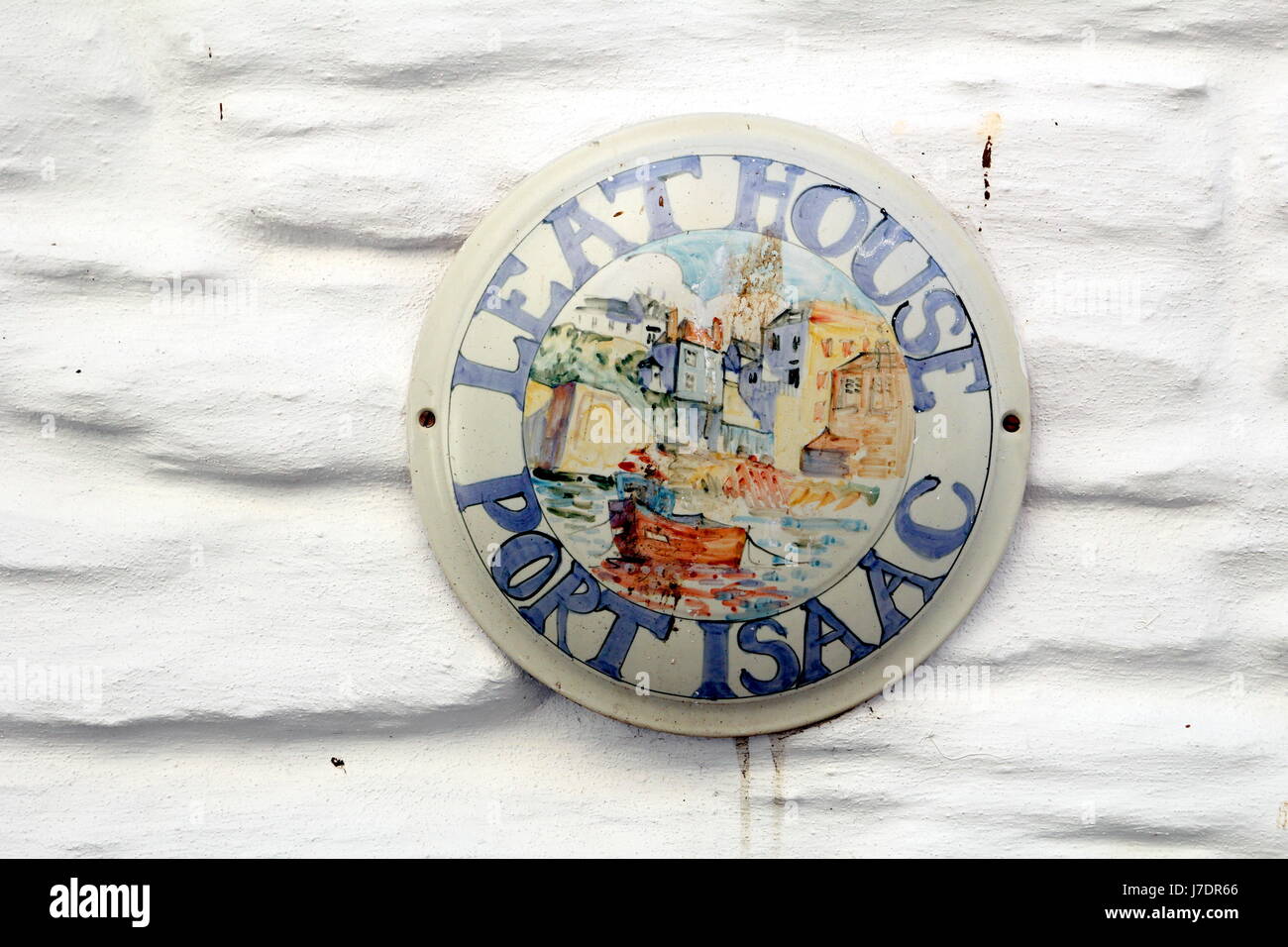 Plaque nom de maison, disant "Leat Maison Port Isaac', sur un mur de brique peint en blanc Banque D'Images