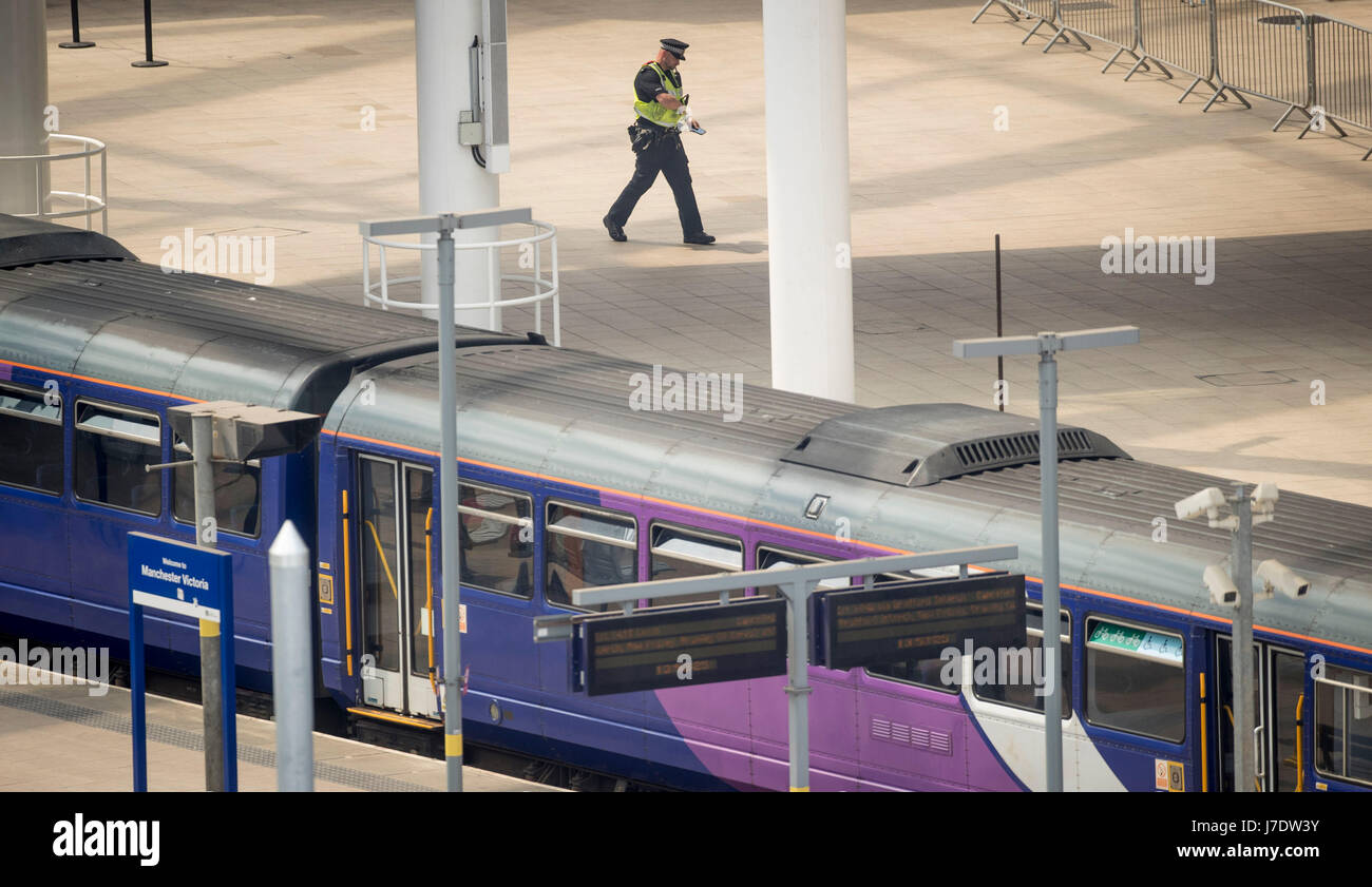 Un agent de police à l'intérieur de la gare de Victoria à Manchester qui reste fermée après un attentat suicide qui a tué 22 personnes en laissant un concert pop à la Manchester Arena lundi soir. Banque D'Images