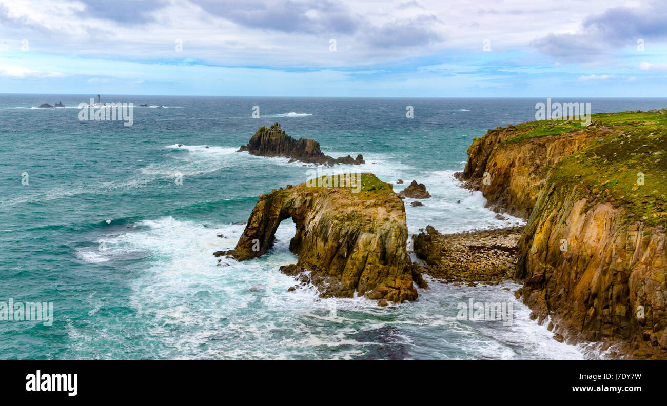 Enys, Dodnan rock un arch environ 1km au sud de Lands End, le chevalier armé et le Reef drakkars peut être vu au-delà. Banque D'Images