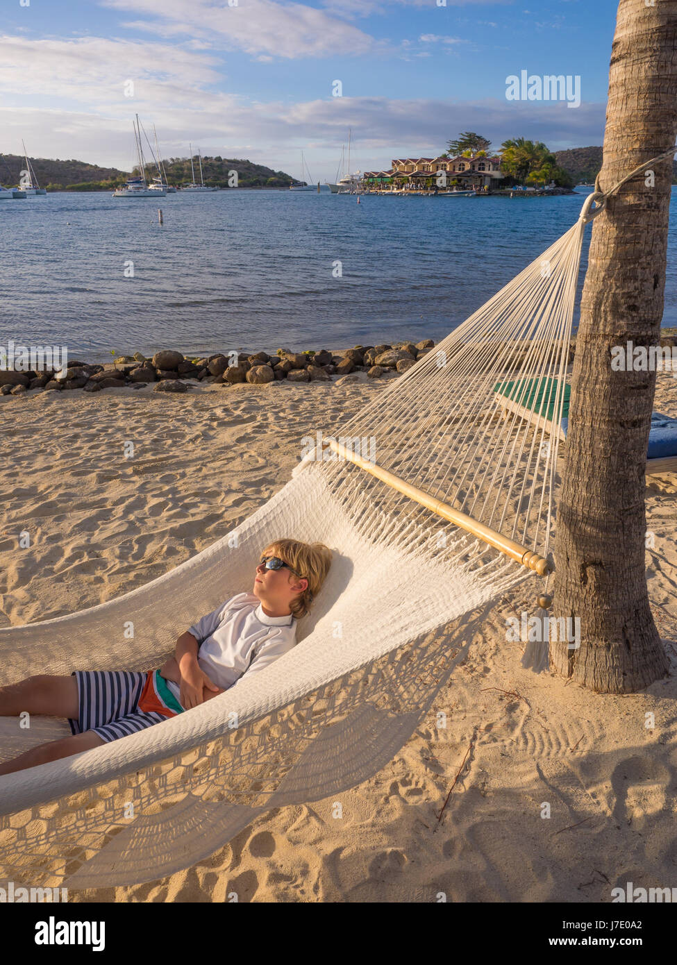 Jeune garçon à lunettes pan dans pendant les vacances dans un hamac au Bitter End Yacht Club dans les îles Vierges britanniques à l'extérieur de l'île de Tortola. Banque D'Images