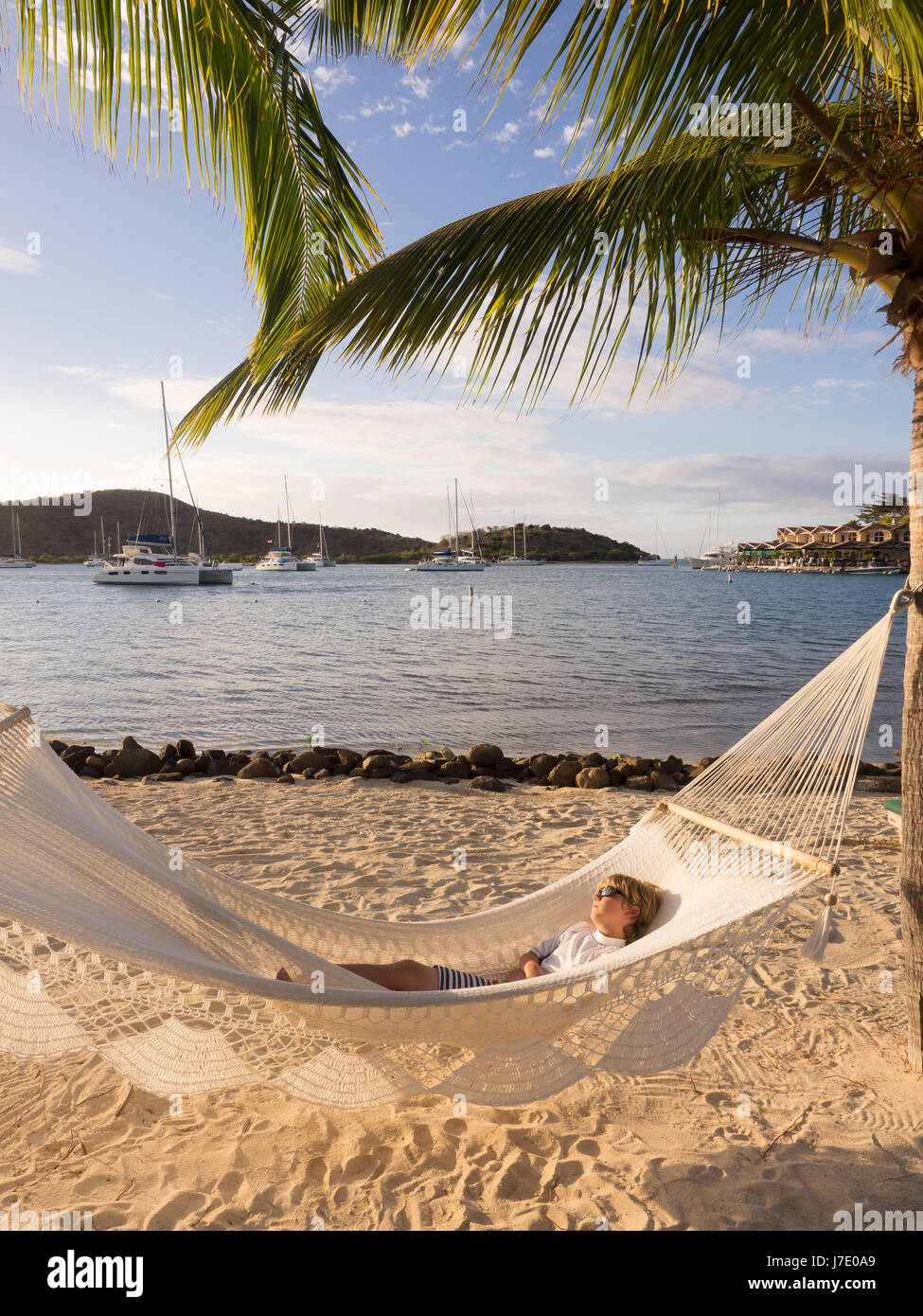 Jeune garçon à lunettes pan dans pendant les vacances dans un hamac au Bitter End Yacht Club dans les îles Vierges britanniques à l'extérieur de l'île de Tortola. Banque D'Images