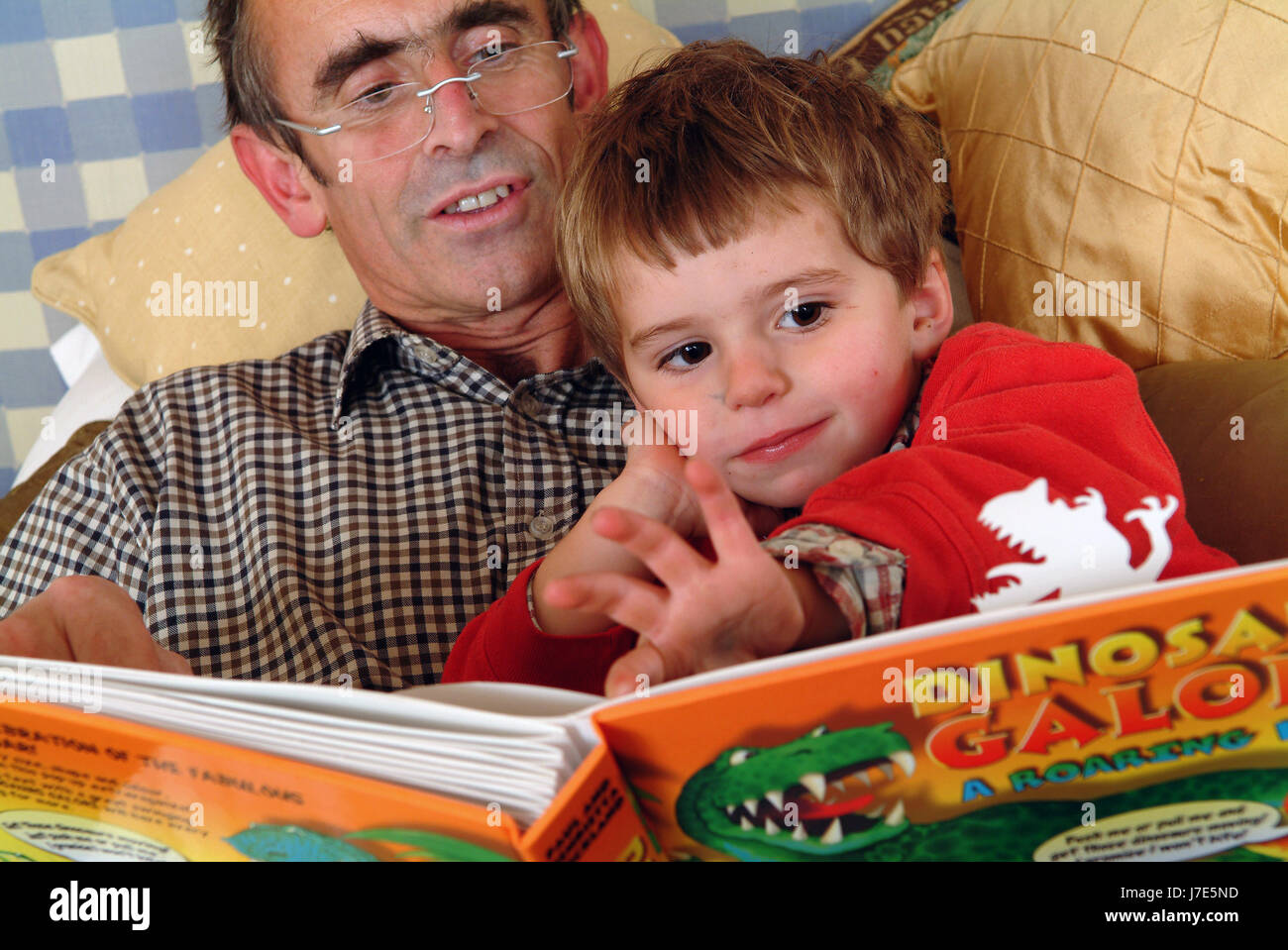Paul Stickland la lecture au lit avec les enfants Arthur (3) en rouge et Felix (11) Banque D'Images