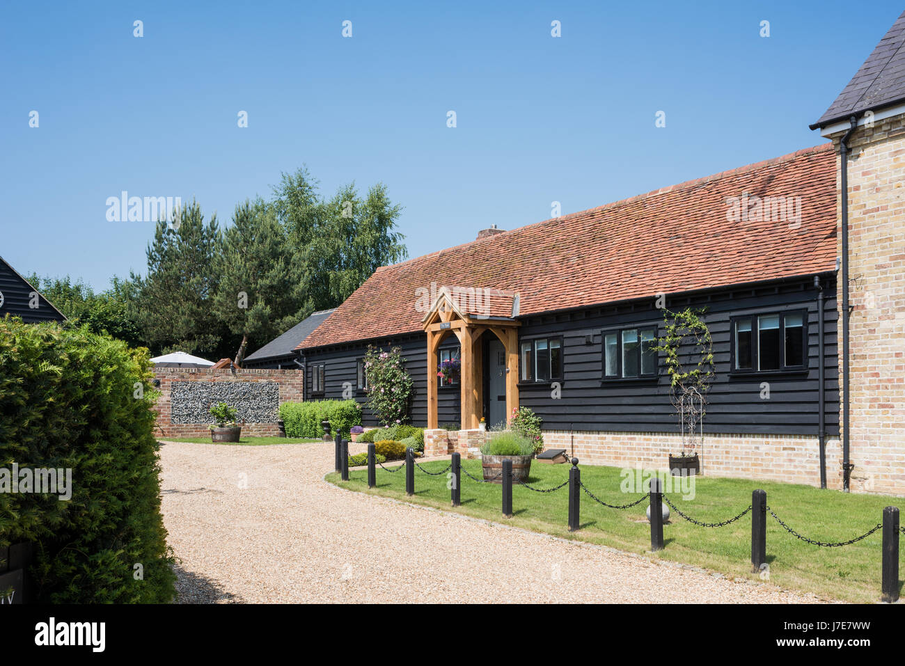 La façade extérieure de l'ancienne grange avec revêtement en bois et toit de tuiles Banque D'Images
