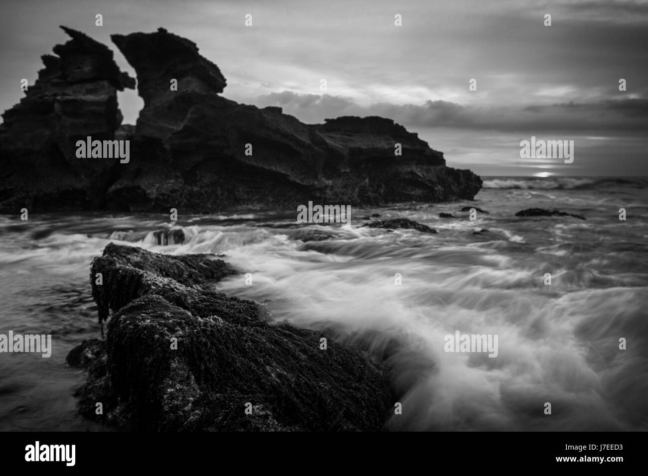 Une image en noir et blanc de forme inhabituelle de la pile de la mer au large des côtes de l'Indonésie Balinais avec un effet de l'exposition Création de mouvement de l'onde Banque D'Images