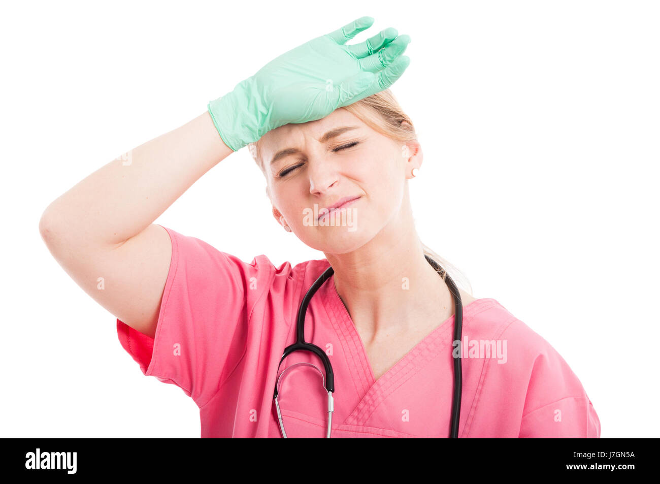 Mignon femelle ayant une infirmière chef ache les yeux fermés et la main sur la tête isolé sur fond blanc Banque D'Images