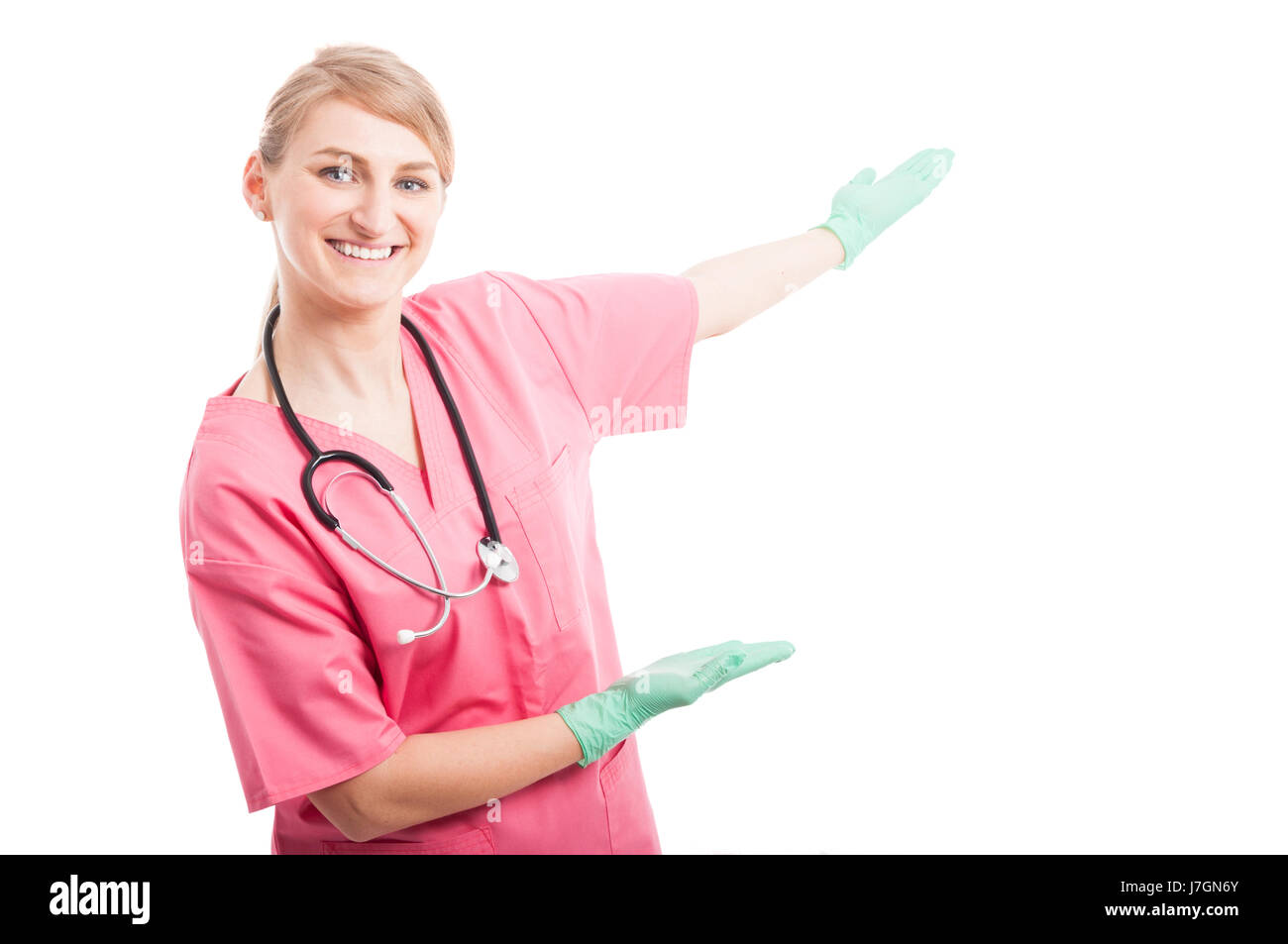 Friendly dame infirmière médicale montrant copyspace et souriant isolé sur fond blanc avec l'espace texte copie Banque D'Images