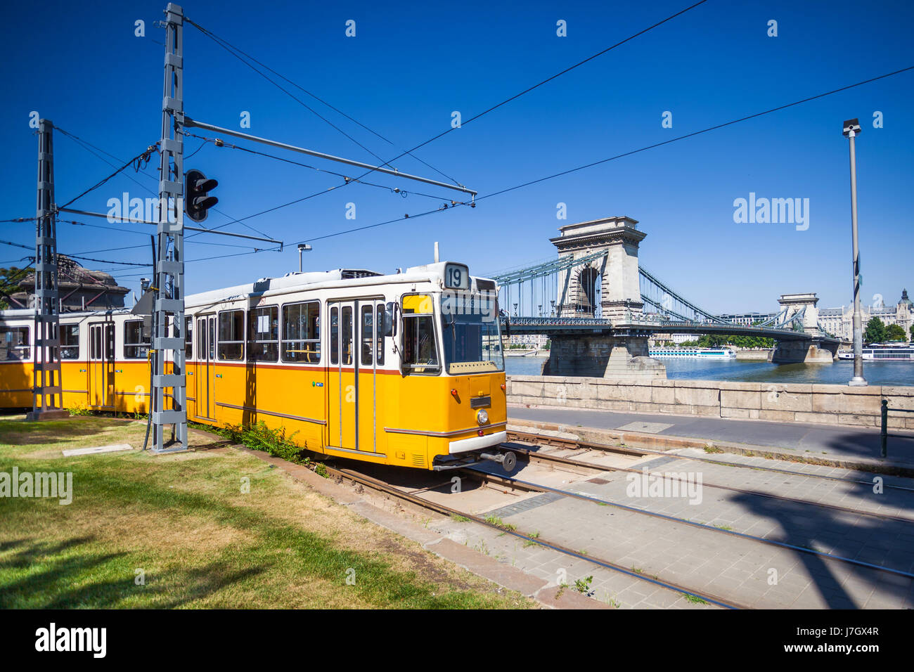 Tramway jaune sur la rive du fleuve de Danube et le Pont des Chaînes à Budapest, Hongrie Banque D'Images