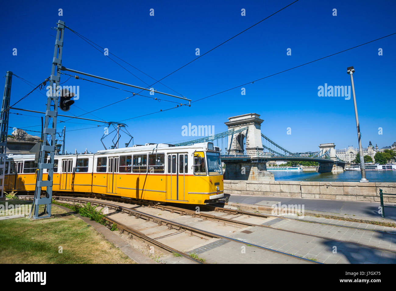 Tramway jaune sur la rive du fleuve de Danube et le Pont des Chaînes à Budapest, Hongrie Banque D'Images
