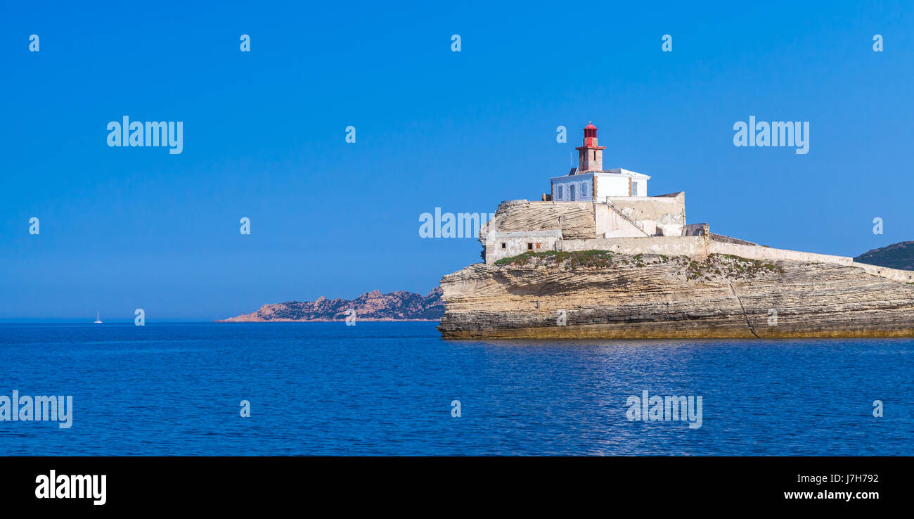 Des voyageurs, avec la tour phare rouge haut sur les côtes de la roche. Entrée au port de Bonifacio. L'île méditerranéenne de montagne Corse, Corse-du-Sud, France Banque D'Images