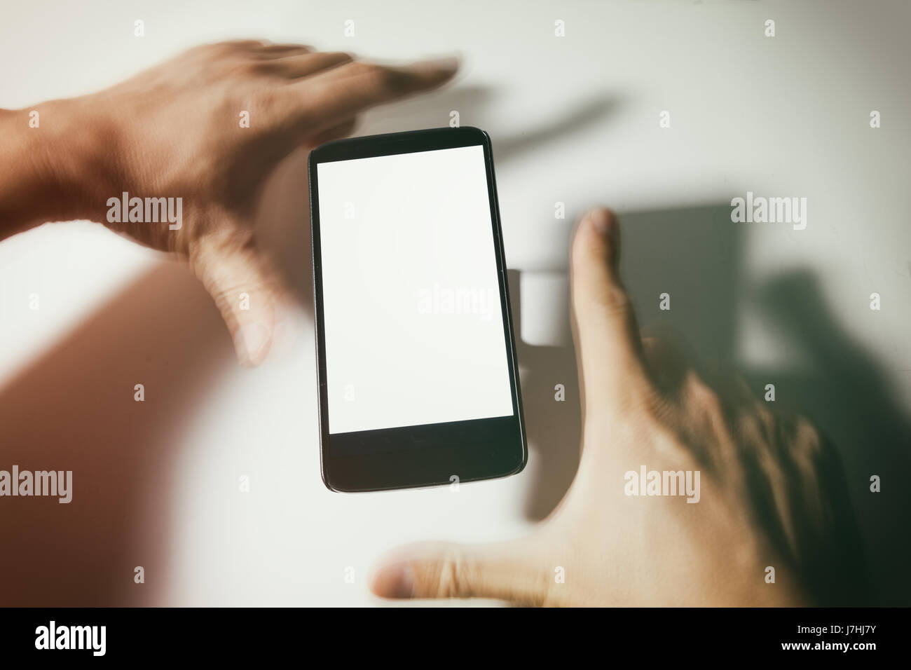 Téléphone cellulaire et d'estomper les mains à l'écran vide. communication concept. Banque D'Images