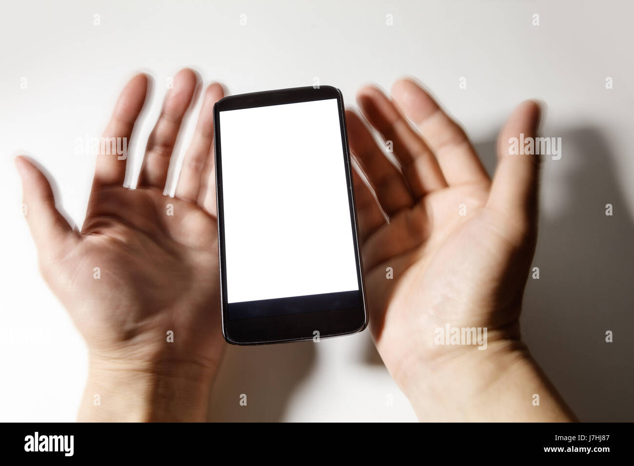Téléphone cellulaire et d'estomper les mains à l'écran vide. communication concept. Banque D'Images