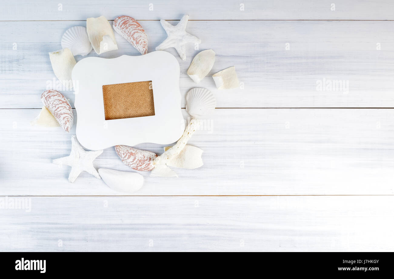 Cadre photo vintage blanc sur la plage de la mer du groupe nautilus accessoires sur table en bois Vue de dessus,des maquettes pour l'affichage des vacances d'été,design concept. Banque D'Images