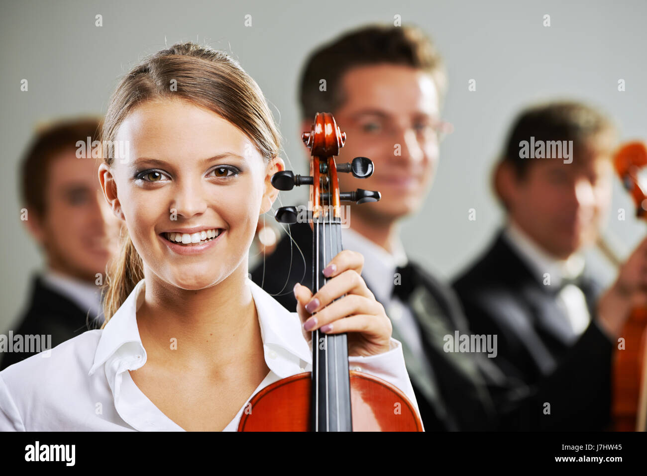 Portrait d'une femme belle violoniste, musiciens sur arrière-plan Banque D'Images