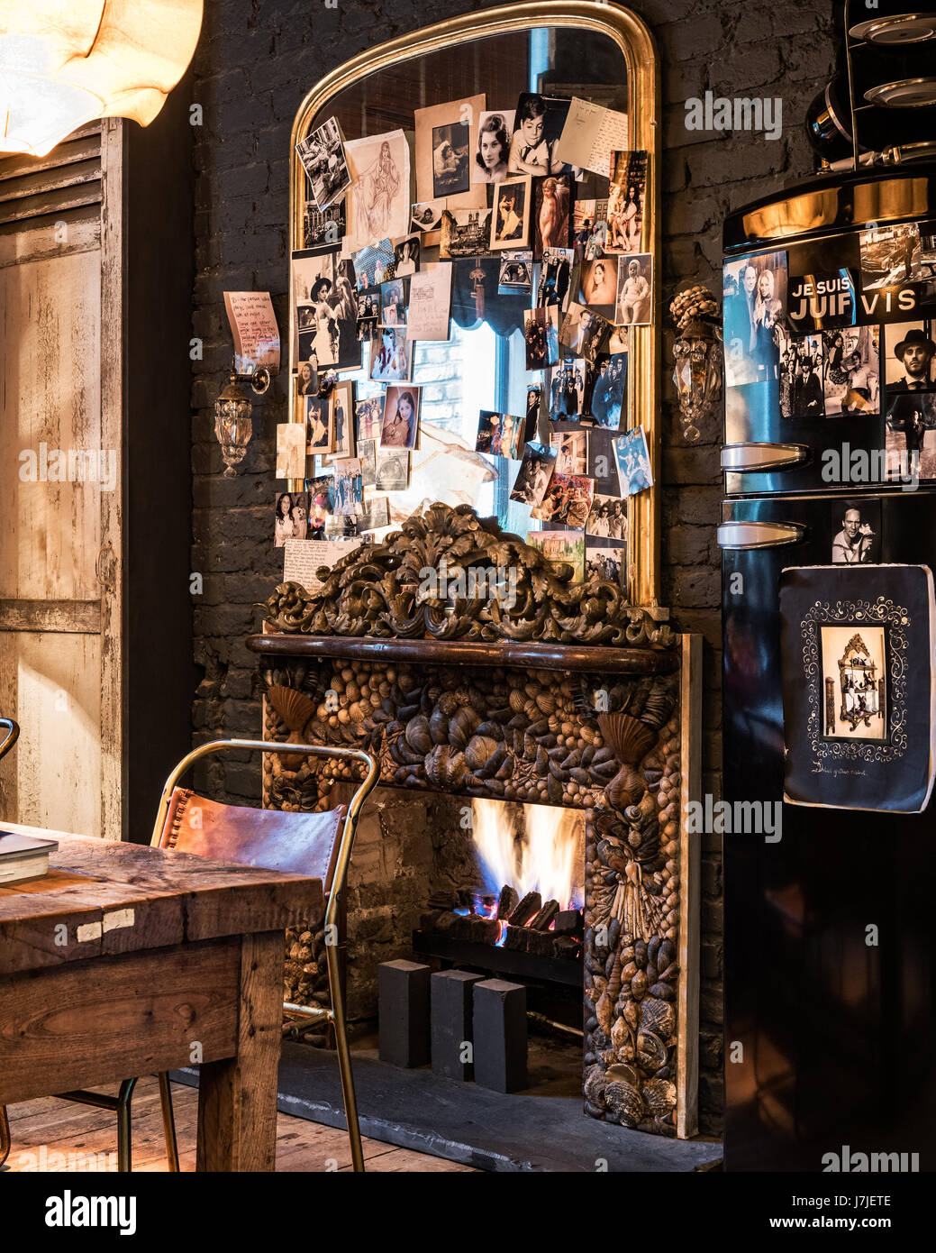 Feu d'obus surround coquilles de fruits et de pierres avec des photographies de famille sur miroir trumeau doré Banque D'Images