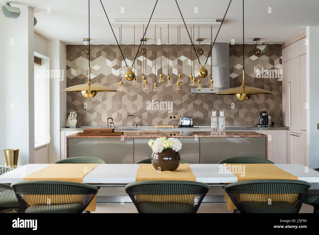 Plan de travail en marbre avec l'île de cuisine Bulthaup et luminaires suspendus en laiton Banque D'Images