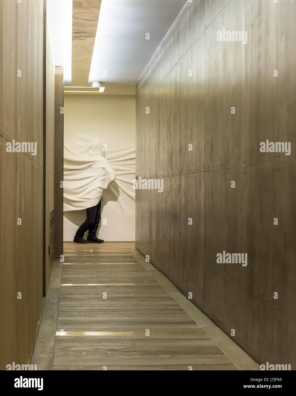 Figure enveloppée de poudre de verre sculpté par Daniel Arsham dans couloir avec murs concerete poli Banque D'Images