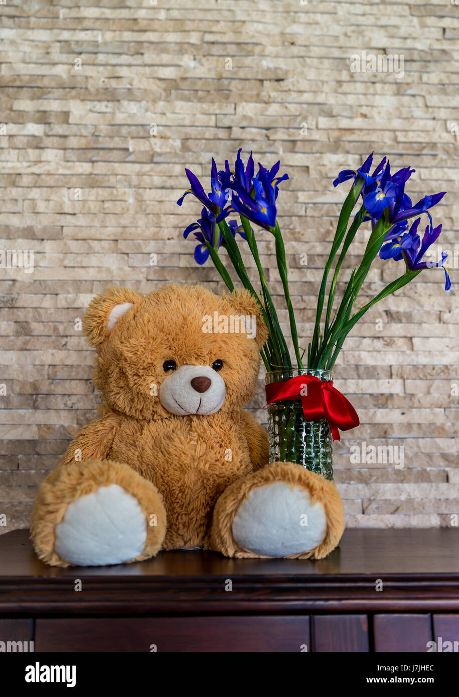 L'ours en peluche et une boucket d'iris en vase en verre. Cadeau Fête des Mères Banque D'Images