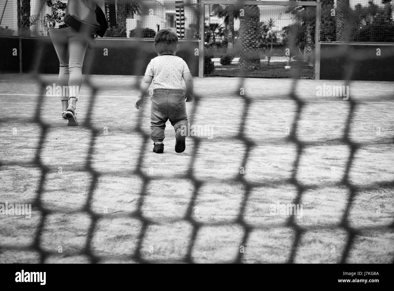 Baby Girl walking à égalité derrière sa mère. Banque D'Images