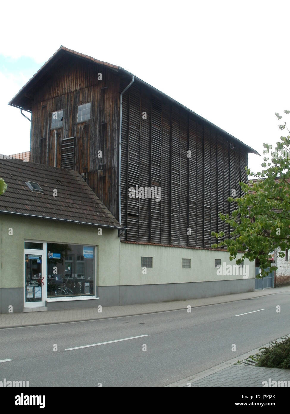 Cette image capture le Tabakscheune à Oftersheim, en Allemagne, prise le 23 juin 2011. La Tabakscheune est une grange à tabac traditionnelle, représentant le patrimoine agricole de la région et son importance historique dans la culture du tabac. Banque D'Images