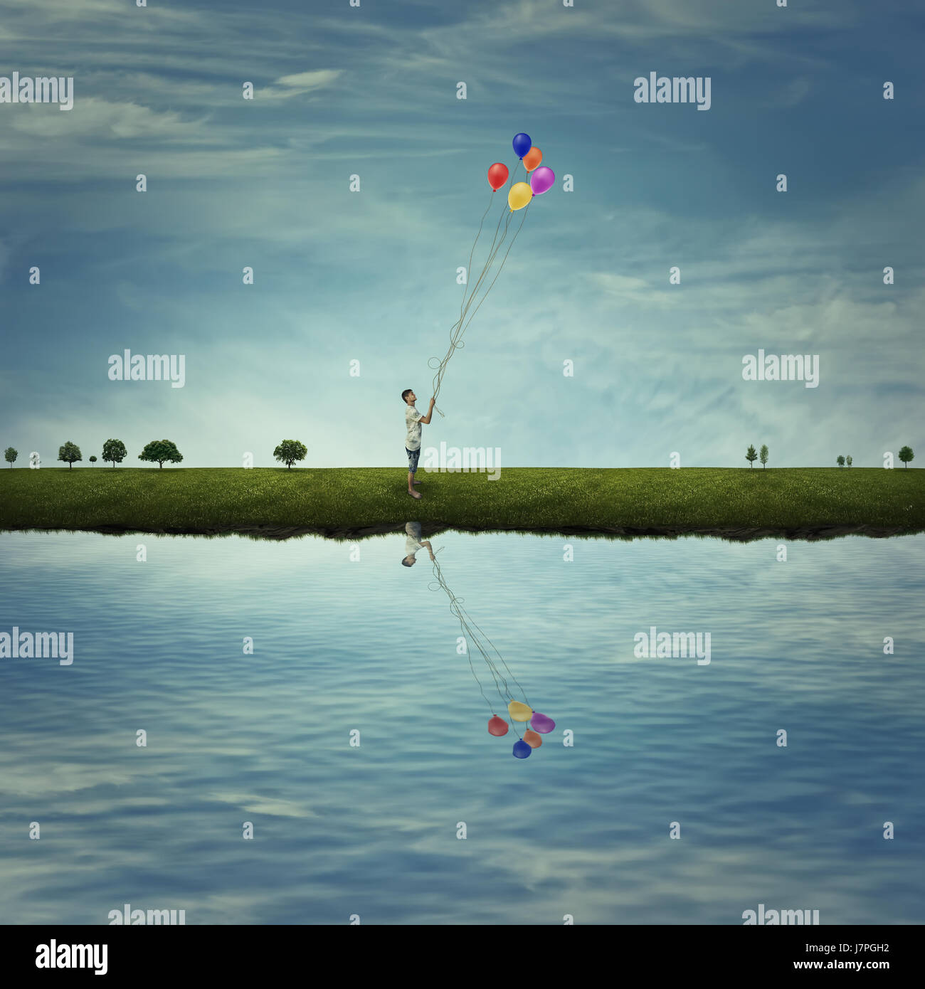 Jeune garçon debout sur un pays prairie près du lac, tenir des ballons colorés. La joie de vie, de plaisir et de bonheur. Banque D'Images