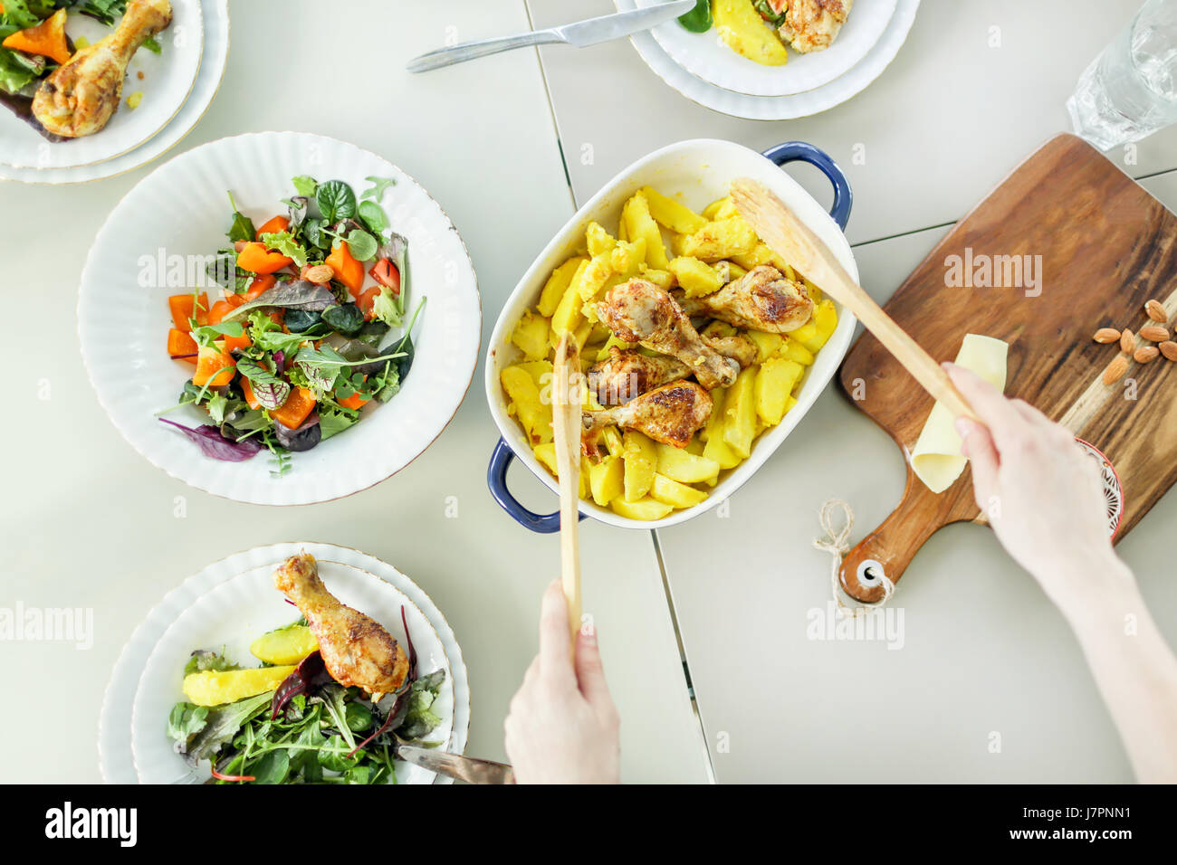 Vue de dessus de femme préparant le poulet grillé avec salade de pommes de terre Banque D'Images