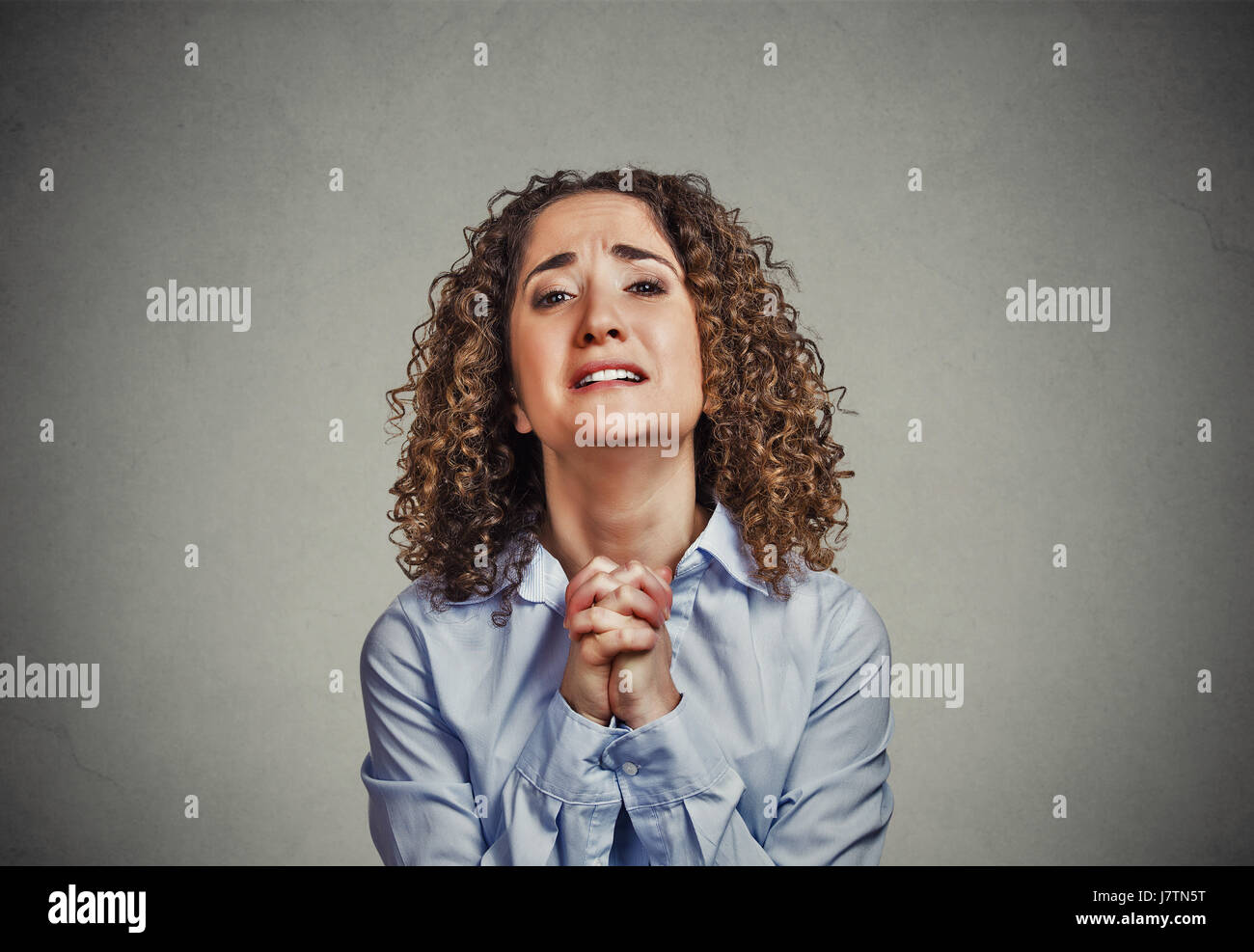 Closeup portrait jeune femme faisant des gestes avec les mains jointes, veuillez plutôt avec du sucre sur le dessus, isolé sur fond gris. les droits de l'expression faciale des émotions Banque D'Images
