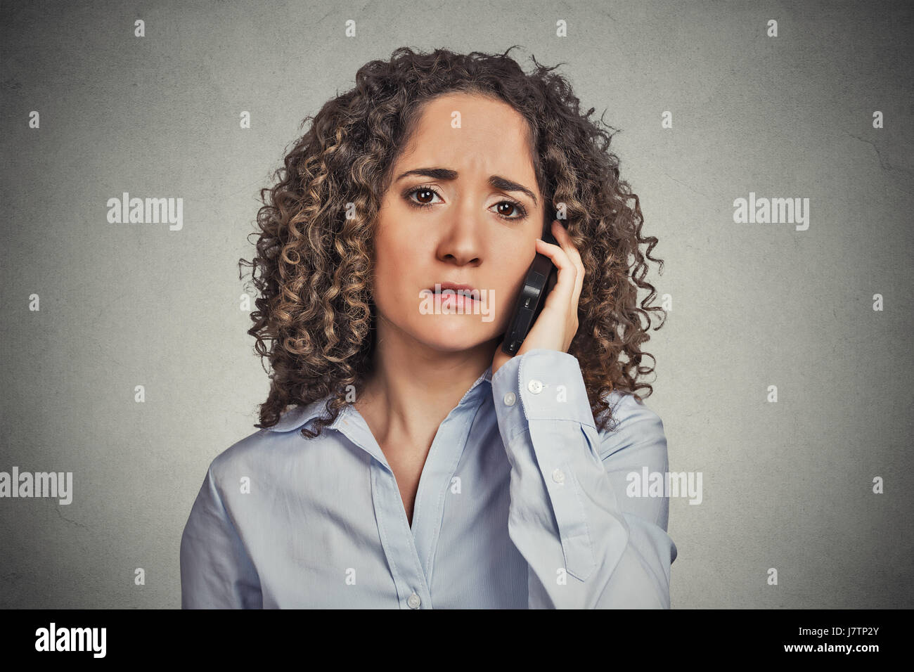 Sad young woman talking on mobile phone Banque D'Images