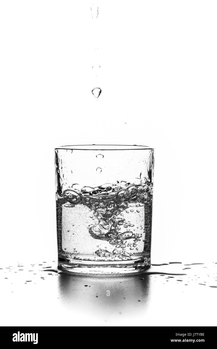 Verser le liquide dans un verre sur un fond blanc Banque D'Images