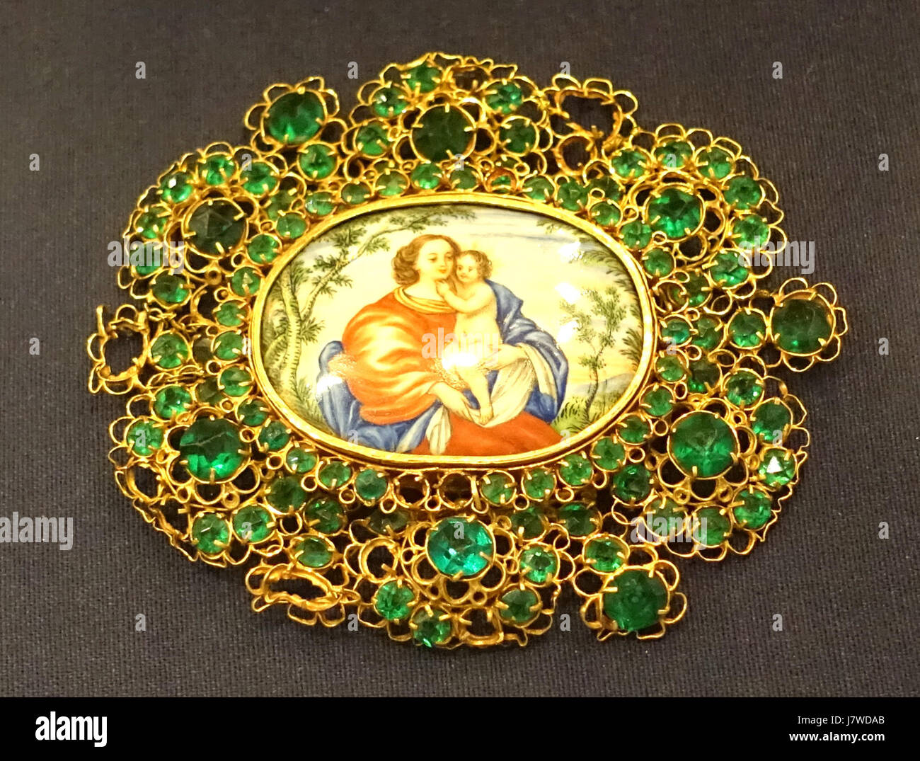 Cette broche du XVIIIe siècle présente la Vierge à l'enfant, confectionnée en filigrane d'or avec des émeraudes et une plaque émaillée. Il est logé dans le Museo Nacional de Artes Decorativas à Madrid, Espagne, représentant l'artisanat espagnol de l'époque. Banque D'Images