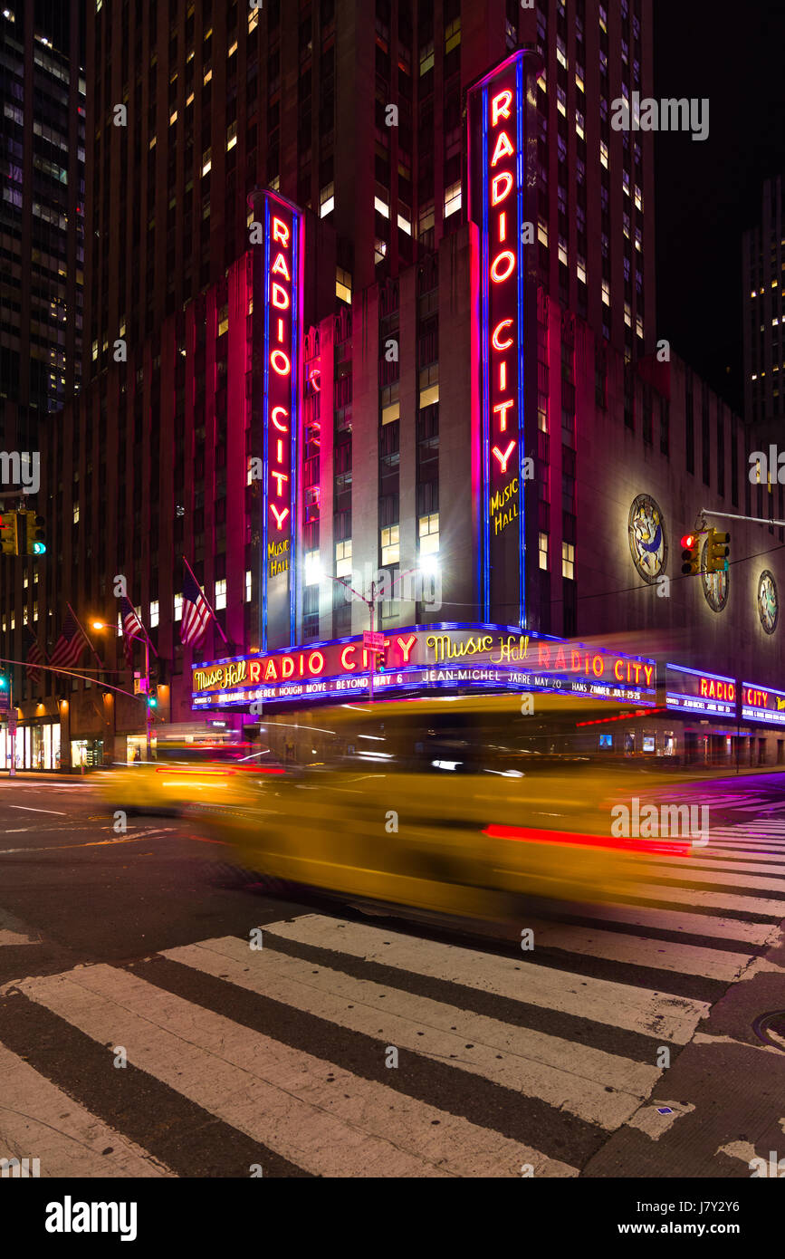 Yellow Taxi Cab Driving passé Radio City Music Hall à New York, la nuit Banque D'Images